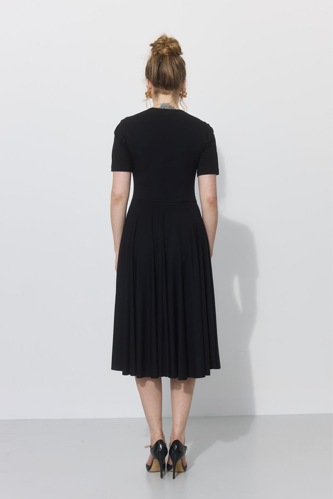 Czarna sukienka midi z krótkim rękawem i plisowaną spódnicą, idealna na co dzień lub na spotkania