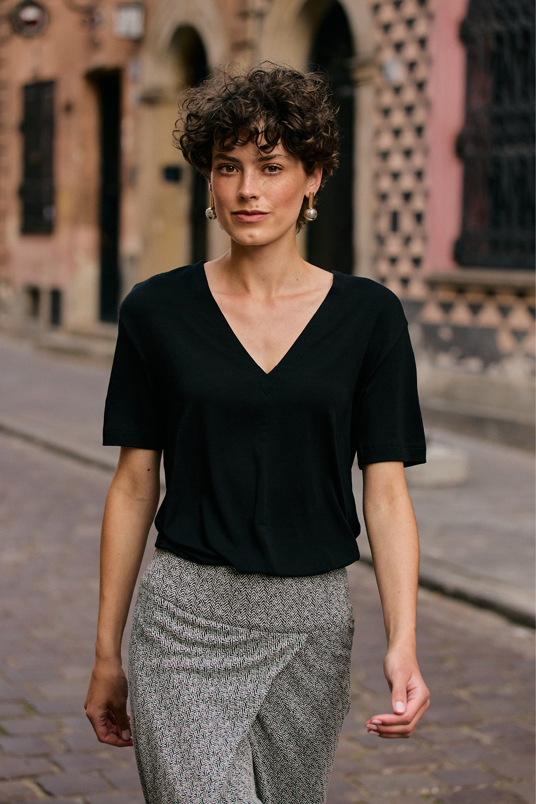Czarna bluzka z dekoltem w serek i spódnica w wzór herringbone, stylowa moda damska na co dzień