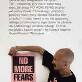Mężczyzna w czarnej koszulce z napisem NO MORE FEARS trzyma plakat z tym samym hasłem – moda z misją, wspierająca QueerMuzeum Warszawa.