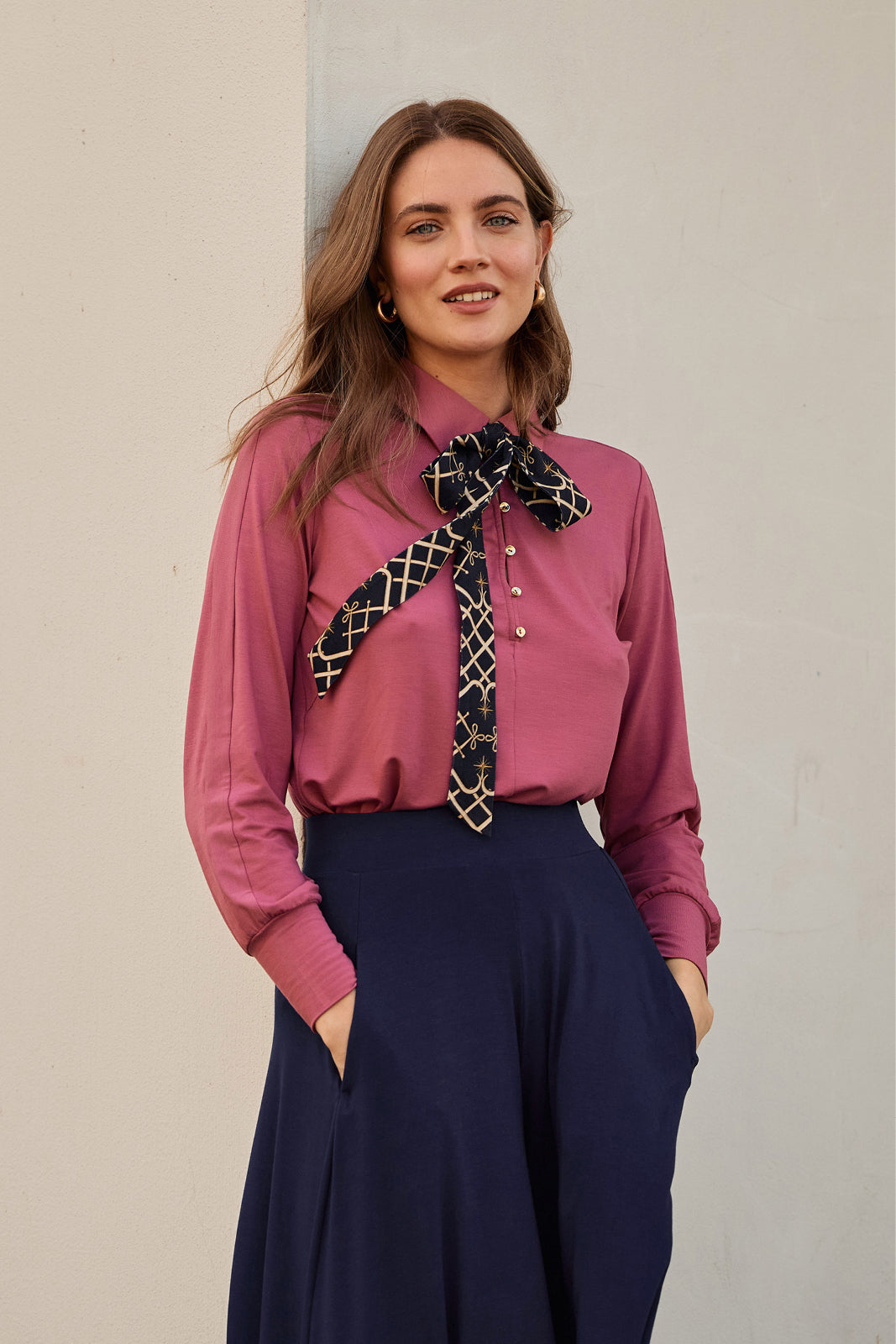 Różowa koszula z kokardą i granatowa spódnica – elegancka stylizacja damska