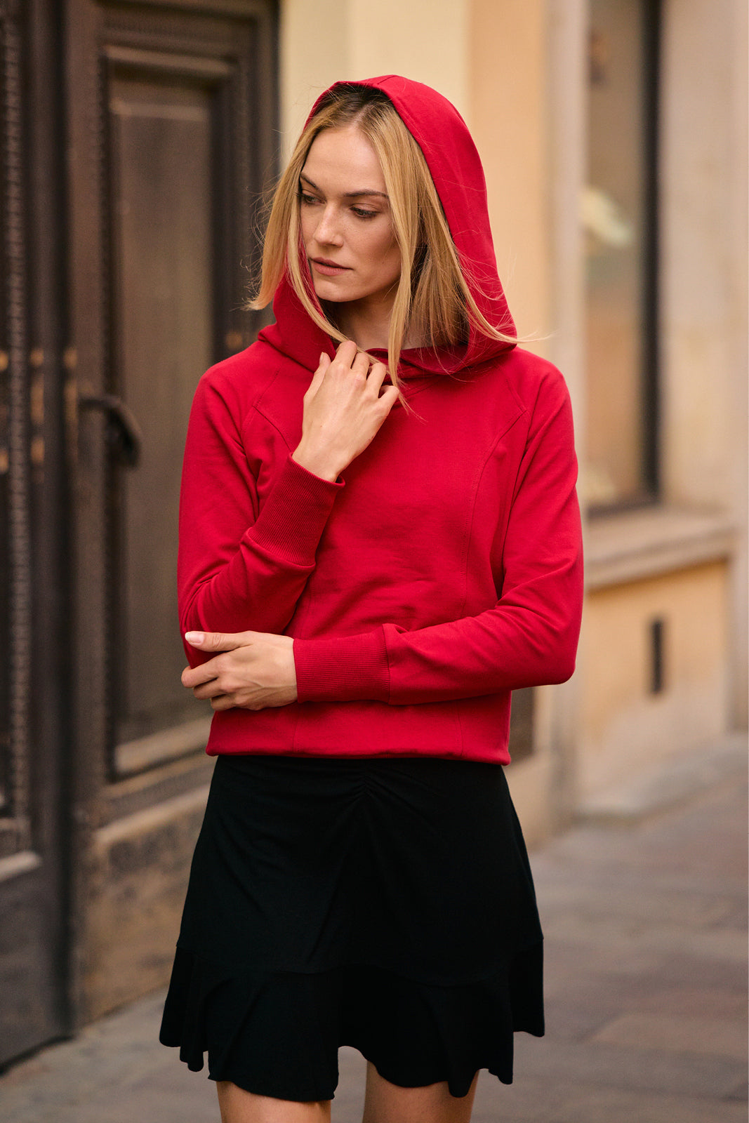 Czerwona bluza z kapturem i czarna spódnica – modna stylizacja na co dzień, wygodna i elegancka