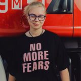 Kobieta w czarnej koszulce z napisem 'NO MORE FEARS', stylowa moda z polskim krawiectwem, self-care fashion