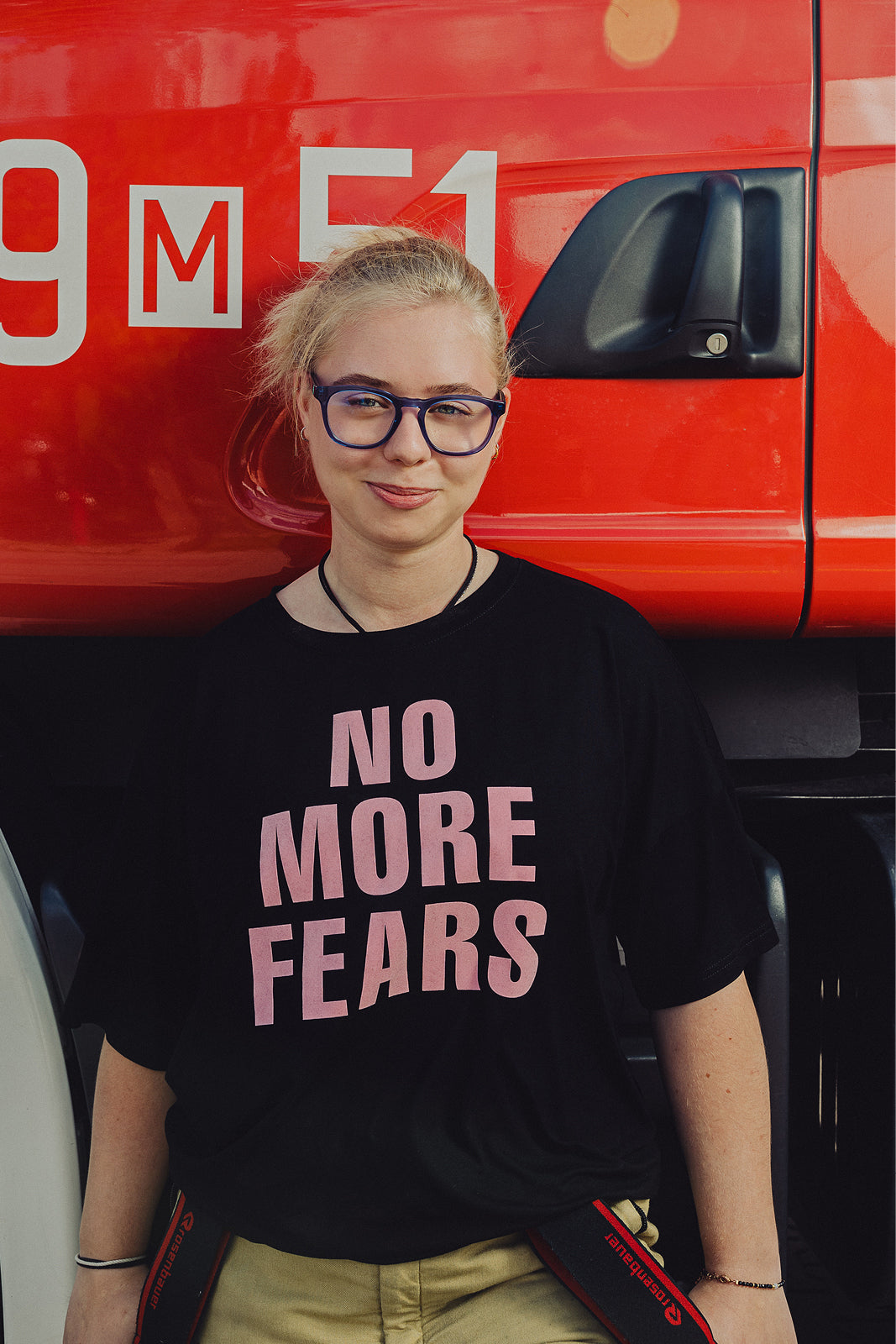 Kobieta w czarnej koszulce z napisem 'NO MORE FEARS', stylowa moda z polskim krawiectwem, self-care fashion