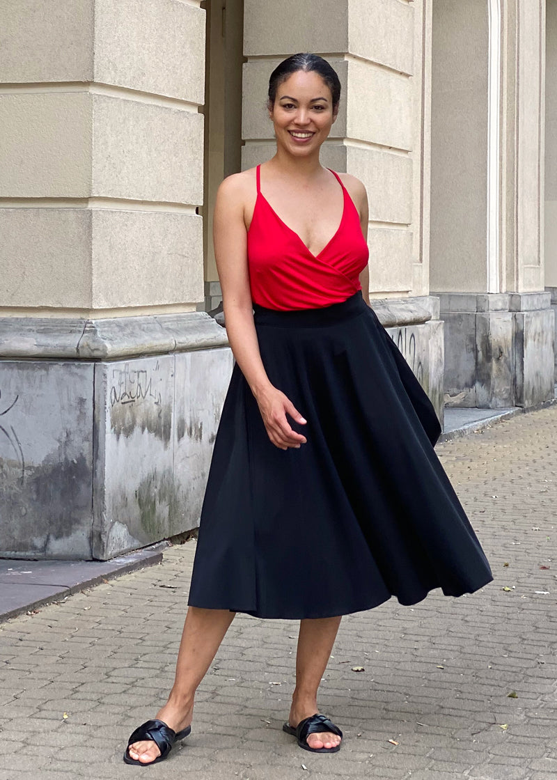 Czerwona bluzka z dekoltem w serek i czarna spódnica midi – elegancka stylizacja na co dzień